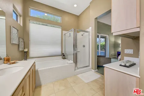 a spacious bathroom with a tub sink and mirror