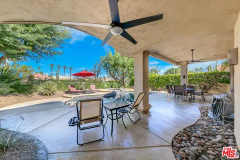 a view of a patio with a dining table and chairs with plants