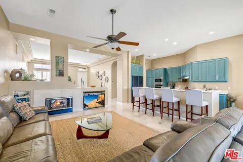 a living room with furniture kitchen view and a fireplace