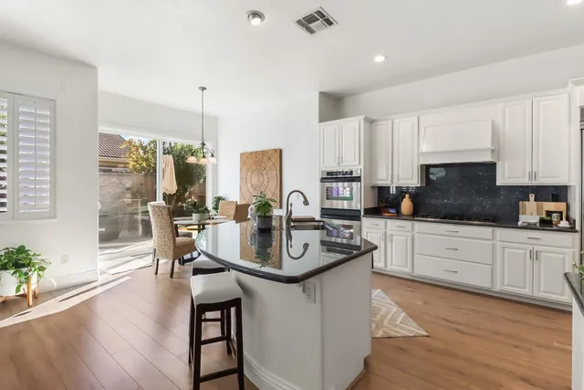 a kitchen with stainless steel appliances granite countertop sink stove top oven and cabinets