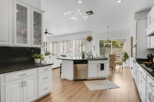 a kitchen with kitchen island granite countertop a sink and a stove