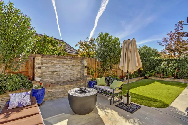 a view of a patio with table and chairs with wooden fence and plants