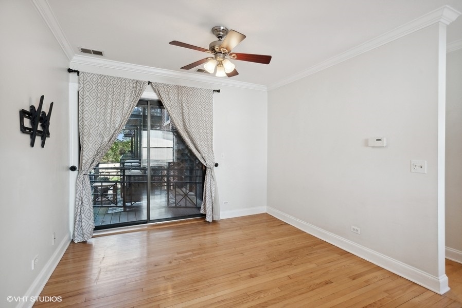 1137 West Grace Street, Unit 2E Chicago, IL 60613 - Photo 2 of 11 wooden floor in an empty room with a window