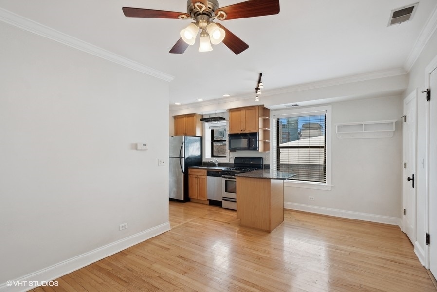 1137 West Grace Street, Unit 2E Chicago, IL 60613 - Photo 3 of 11 a kitchen with stainless steel appliances a stove top oven a sink dishwasher and a microwave