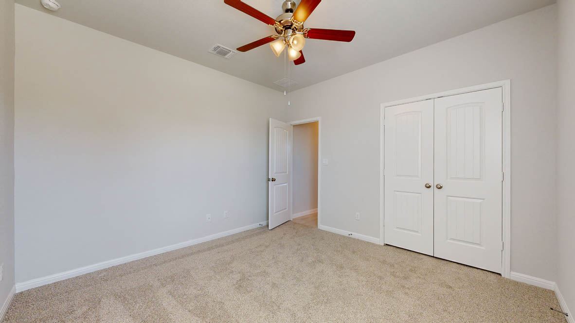 808 Gauge Road Thorndale, TX 76577 - Photo 24 of 31 A comfortable bedroom features carpet flooring and a practical ceiling fan for year-round comfort.