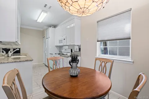 a view of a dining room with furniture a chandelier and wooden floor