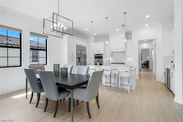 a view of a dining room and livingroom with furniture wooden floor a rug a chandelier