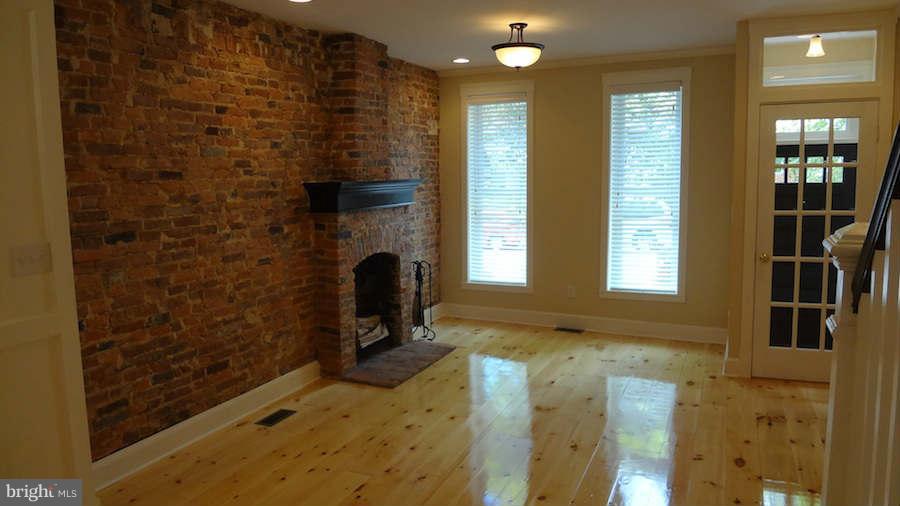 3037 Keswick Road Baltimore, MD 21211 - Photo 12 of 30 Living Room with exposed brick & cozy fireplace