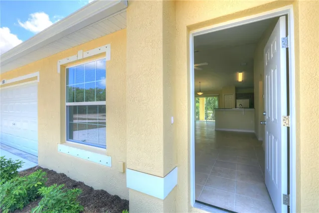 a view of a hallway with wooden floor and a bathroom