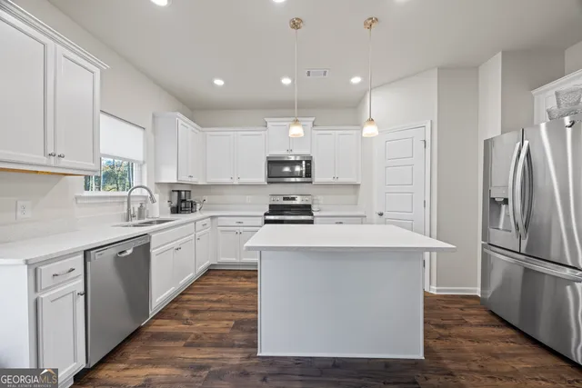 a kitchen with white cabinets and a window
