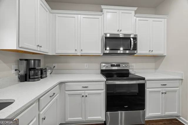 a kitchen with white cabinets and stainless steel appliances