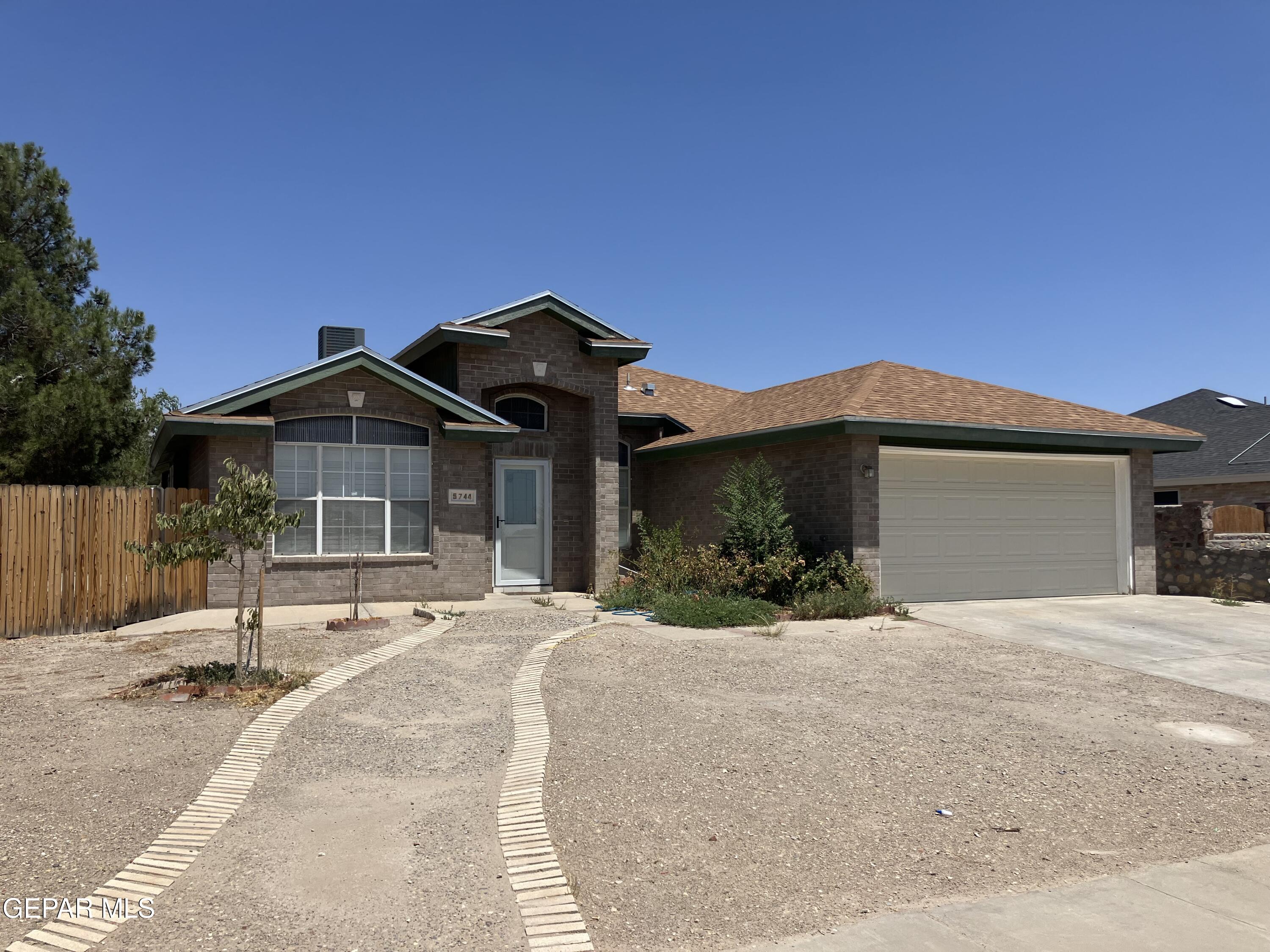 5744 Saplinas Road El Paso, TX 79932 - Photo 1 of 1 a front view of a house with a yard and garage