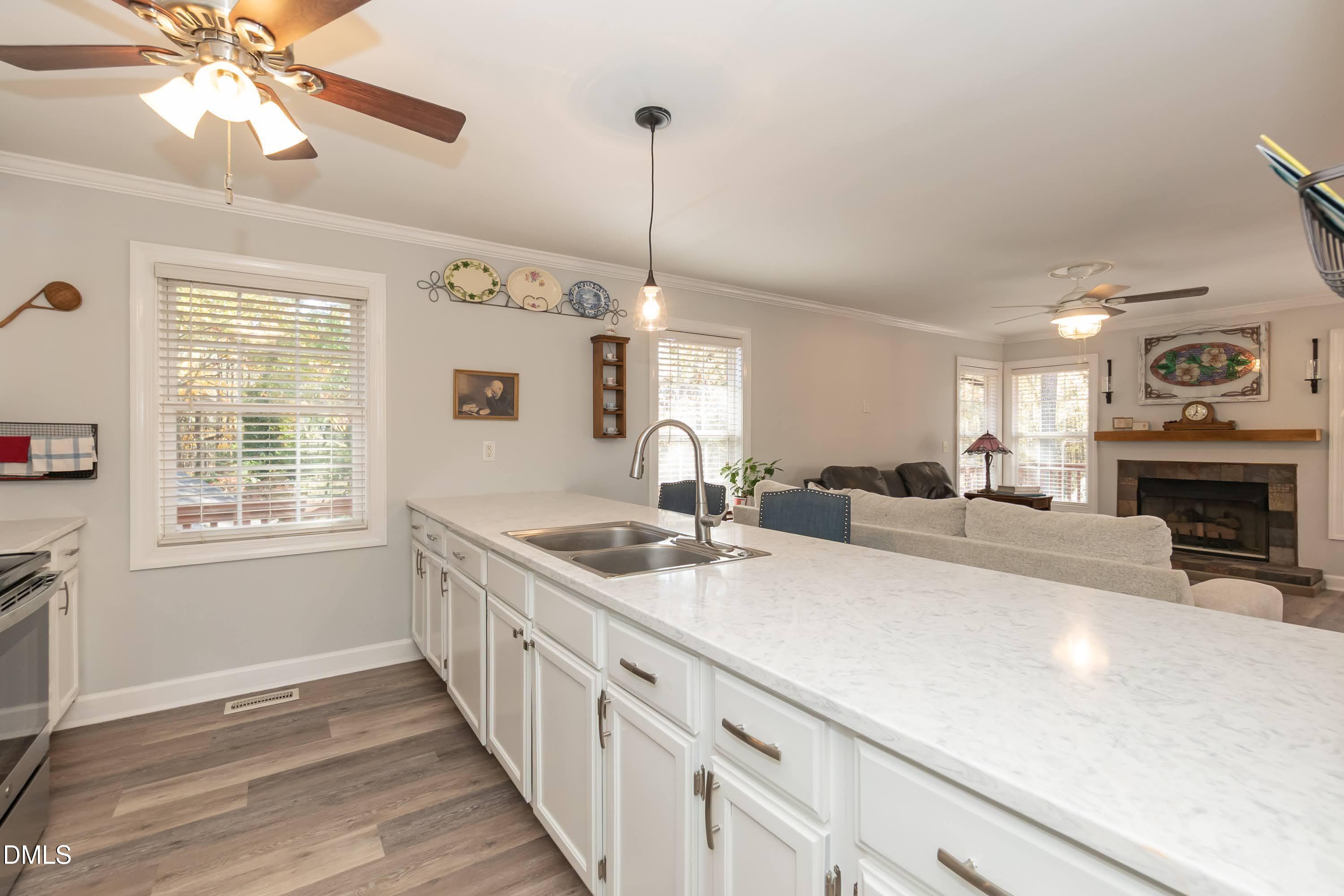 137 Fox Hunters Lane Broadway, NC 27505 - Photo 11 of 46 a hall with kitchen island a stove a wooden floor and a chandelier