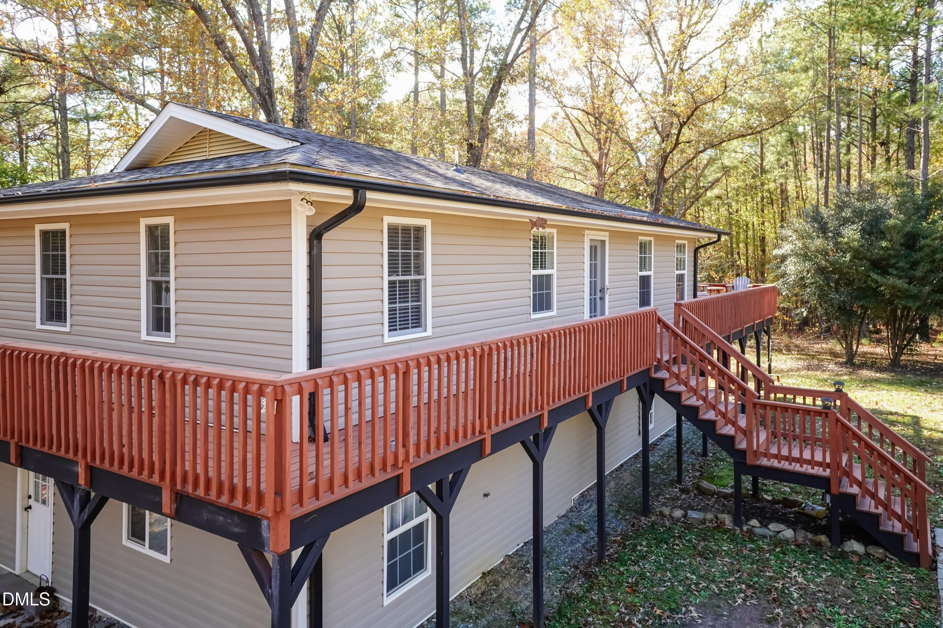 137 Fox Hunters Lane Broadway, NC 27505 - Photo 5 of 46 a view of a house with a wooden deck and a yard