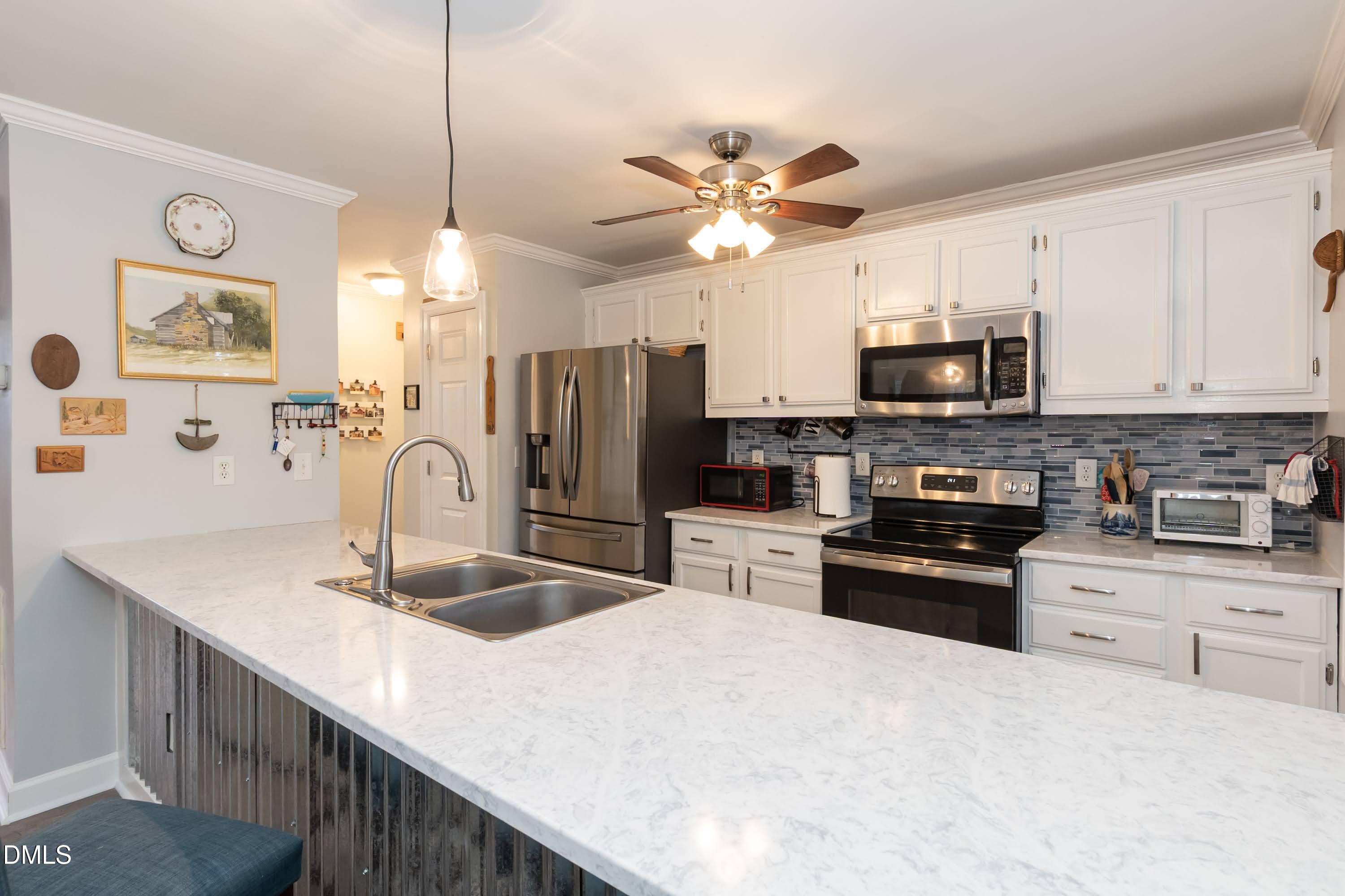137 Fox Hunters Lane Broadway, NC 27505 - Photo 10 of 46 a kitchen with stainless steel appliances a stove sink microwave and refrigerator