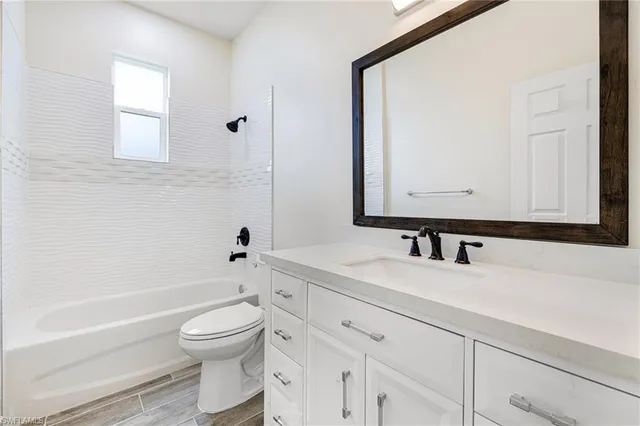 a bathroom with a toilet a sink a mirror and a bathtub