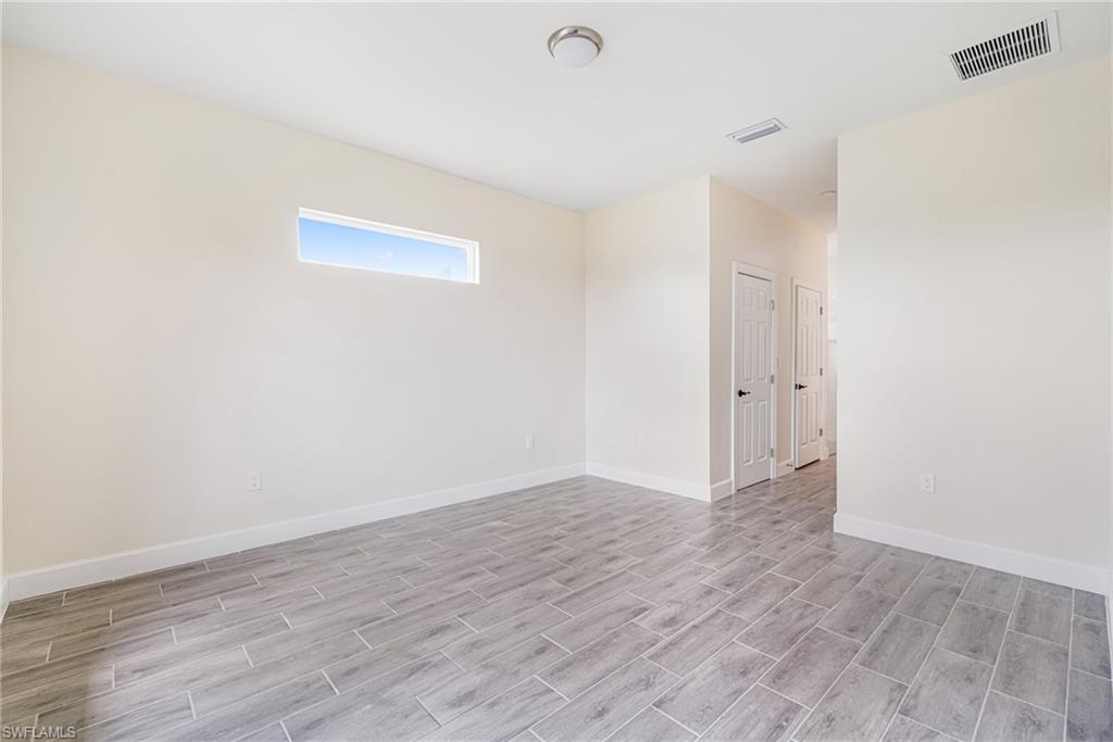 4909 Berryman Street Lehigh Acres, FL 33971 - Photo 18 of 30 Empty room with wood tiled floors and baseboards