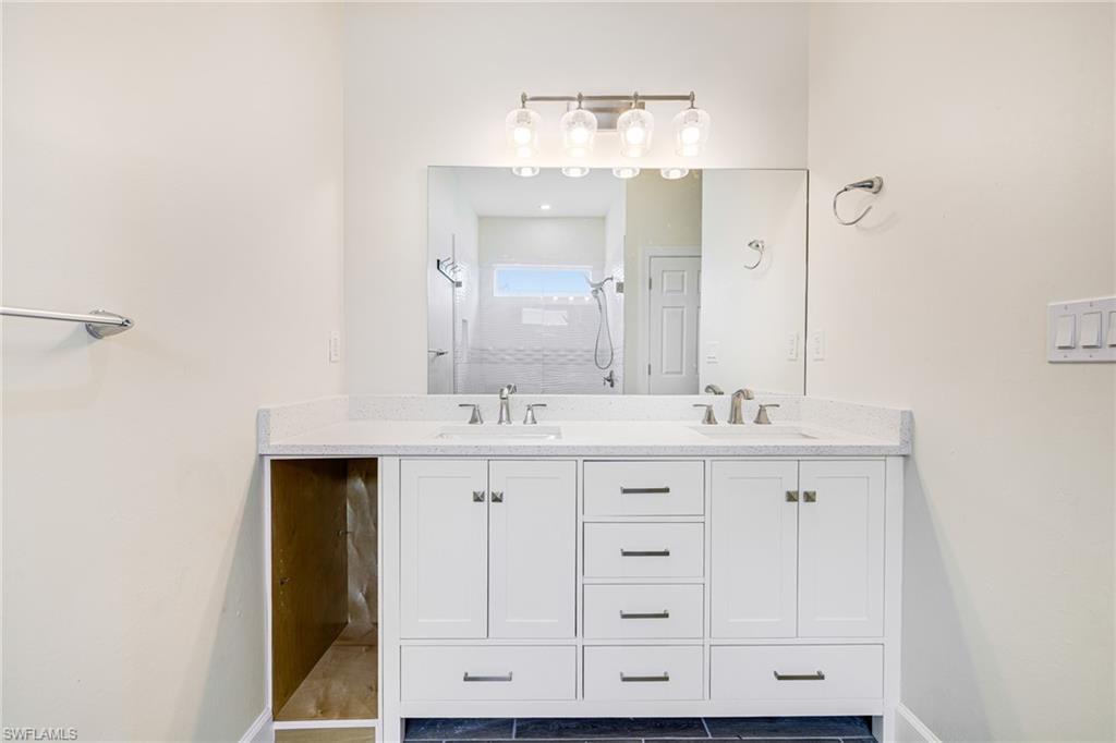 4909 Berryman Street Lehigh Acres, FL 33971 - Photo 22 of 30 Full bath with double vanity, walk in shower, and light tile patterned floors