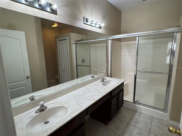 a bathroom with a double vanity sink and a mirror