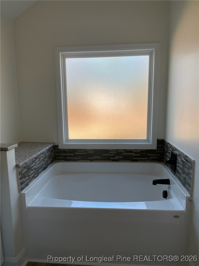 209 August Lane Raeford, NC 28376 - Photo 14 of 20 a bathroom with a bathtub and a window