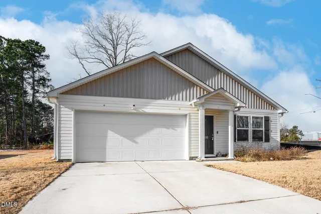 a front view of a house with yard and trees