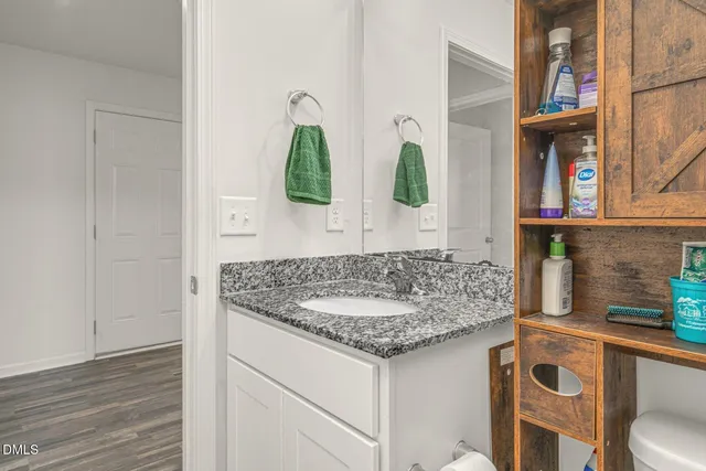 a bathroom with a granite countertop sink and a mirror