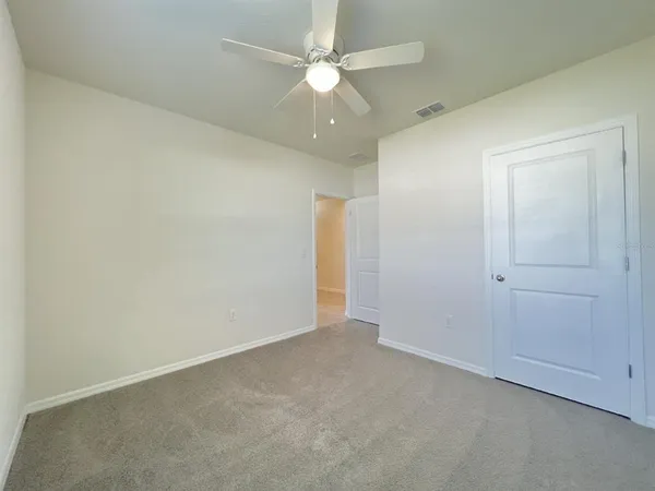 an empty room with a ceiling fan and a fan