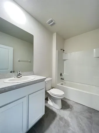 a bathroom with a double vanity sink toilet mirror and bathtub