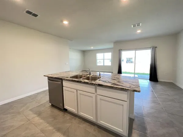 a kitchen with granite countertop a sink and a stove