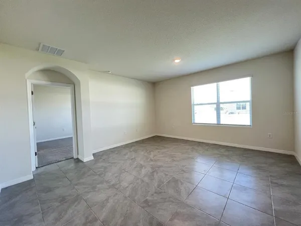 an empty room with a window and a bathroom