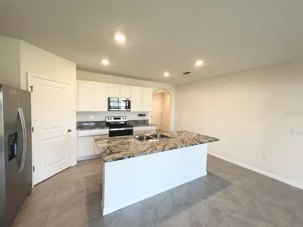 a kitchen with stainless steel appliances granite countertop a refrigerator a stove and a refrigerator