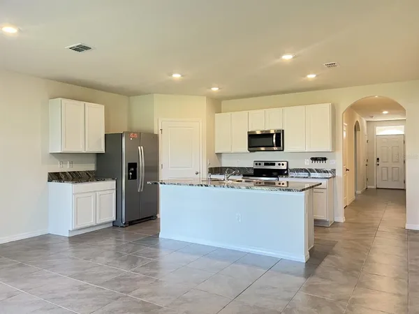 a kitchen with stainless steel appliances granite countertop a refrigerator and a stove top oven