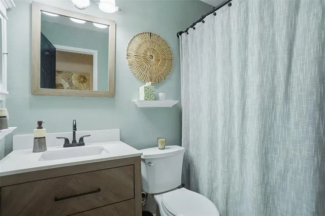 a bathroom with a toilet a sink and a mirror