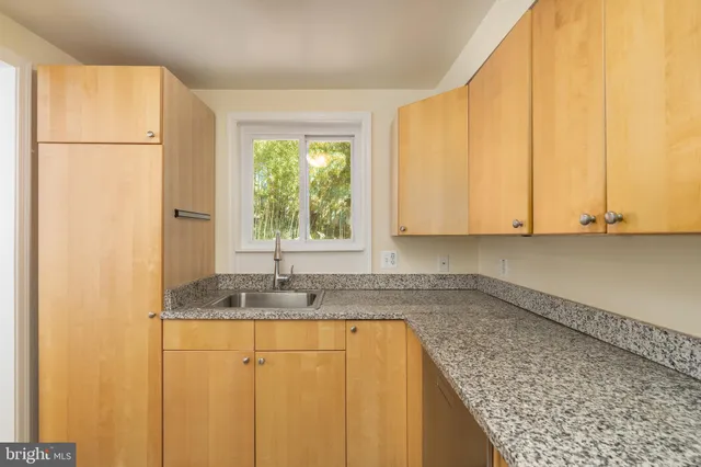 a kitchen with granite countertop cabinets and window