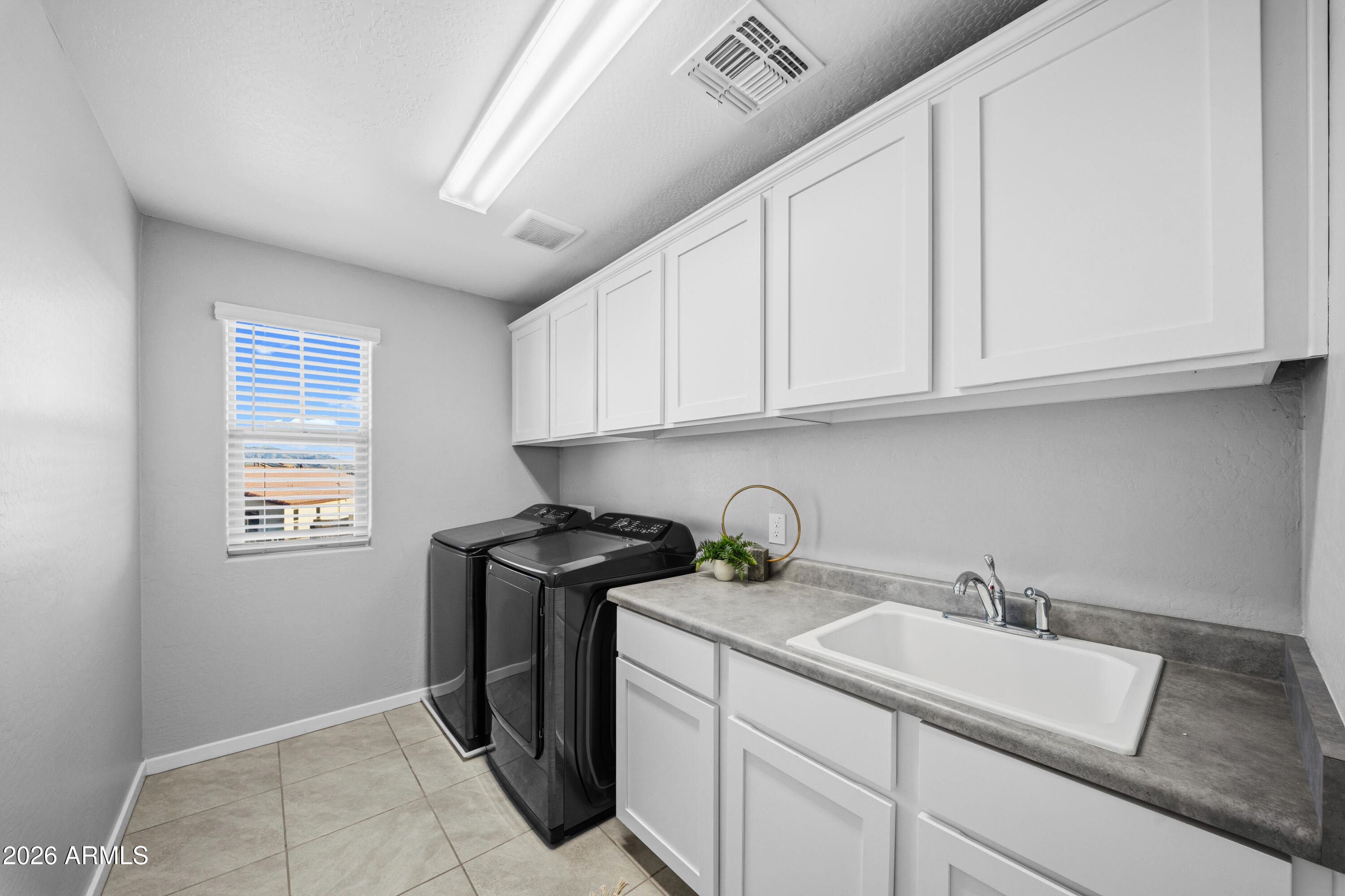 15754 West Madison Street Goodyear, AZ 85338 - Photo 23 of 35 a kitchen with stainless steel appliances granite countertop a sink stove and cabinets