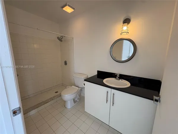 a bathroom with a granite countertop toilet sink and mirror