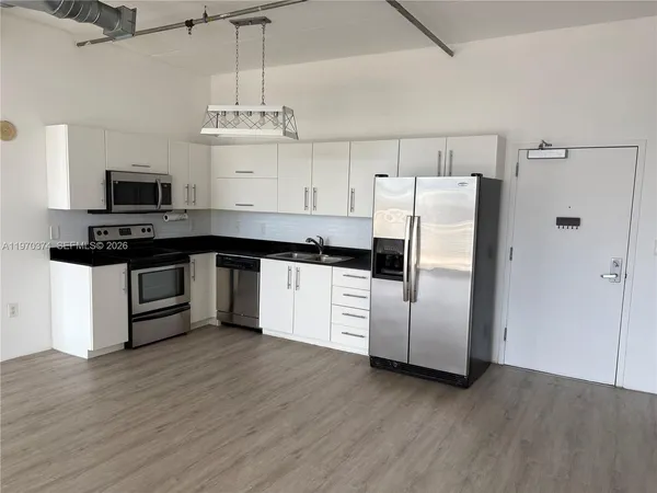 a kitchen with stainless steel appliances a stove a refrigerator and a sink
