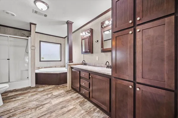a spacious bathroom with a tub sink and mirror