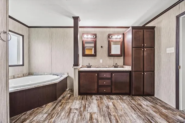 a spacious bathroom with a granite countertop sink a mirror and shower
