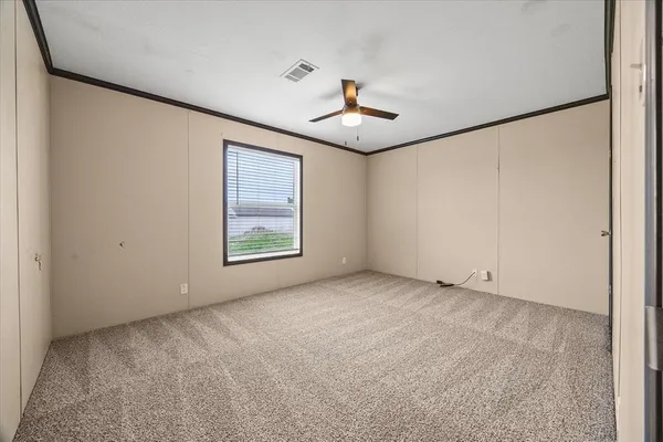an empty room with windows and fan