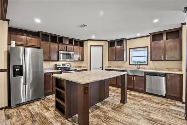 a kitchen with stainless steel appliances granite countertop a sink stove and refrigerator