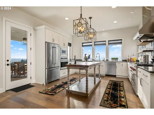 a kitchen with stainless steel appliances kitchen island granite countertop a refrigerator and microwave