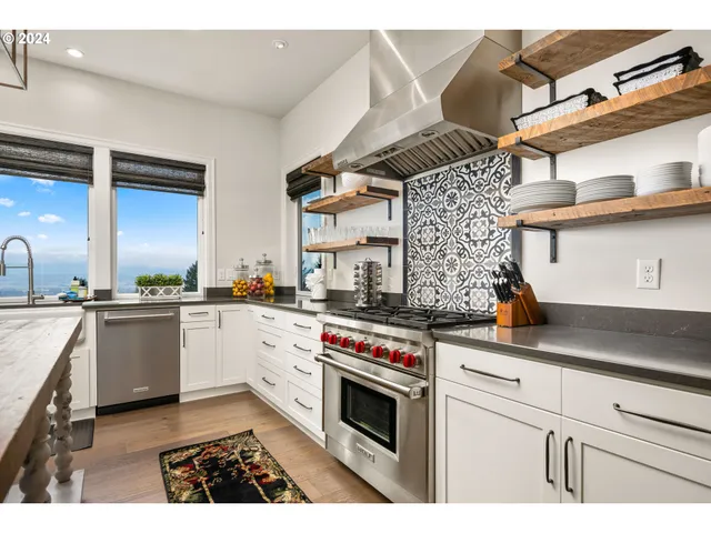 a kitchen with stainless steel appliances granite countertop a stove a sink and a microwave