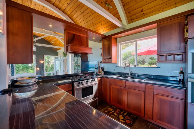 a kitchen with stainless steel appliances granite countertop a stove a sink and a microwave