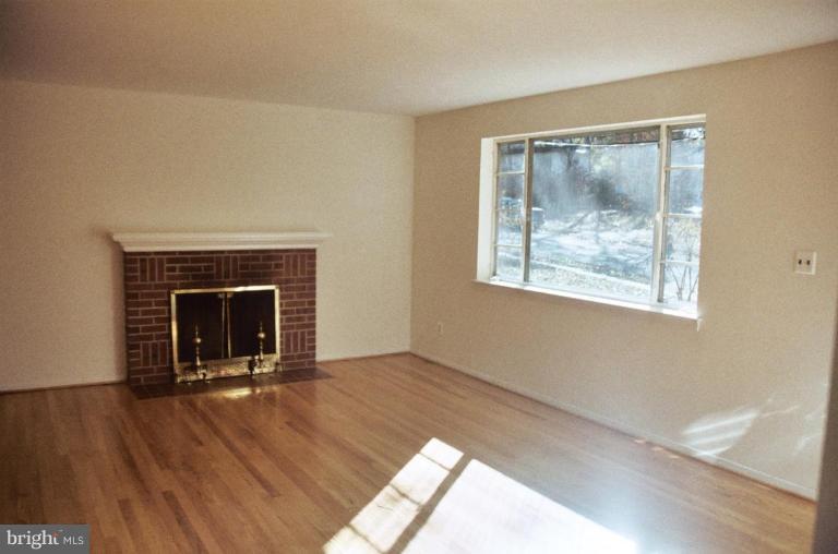 7426 Flora Street Springfield, VA 22150 - Photo 2 of 16 a view of an empty room with wooden floor and a window