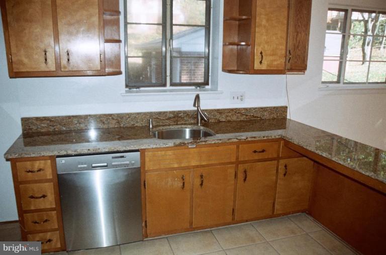 7426 Flora Street Springfield, VA 22150 - Photo 4 of 16 a kitchen with stainless steel appliances granite countertop a sink and a cabinets