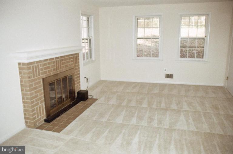 7426 Flora Street Springfield, VA 22150 - Photo 8 of 16 an empty room with windows and fireplace