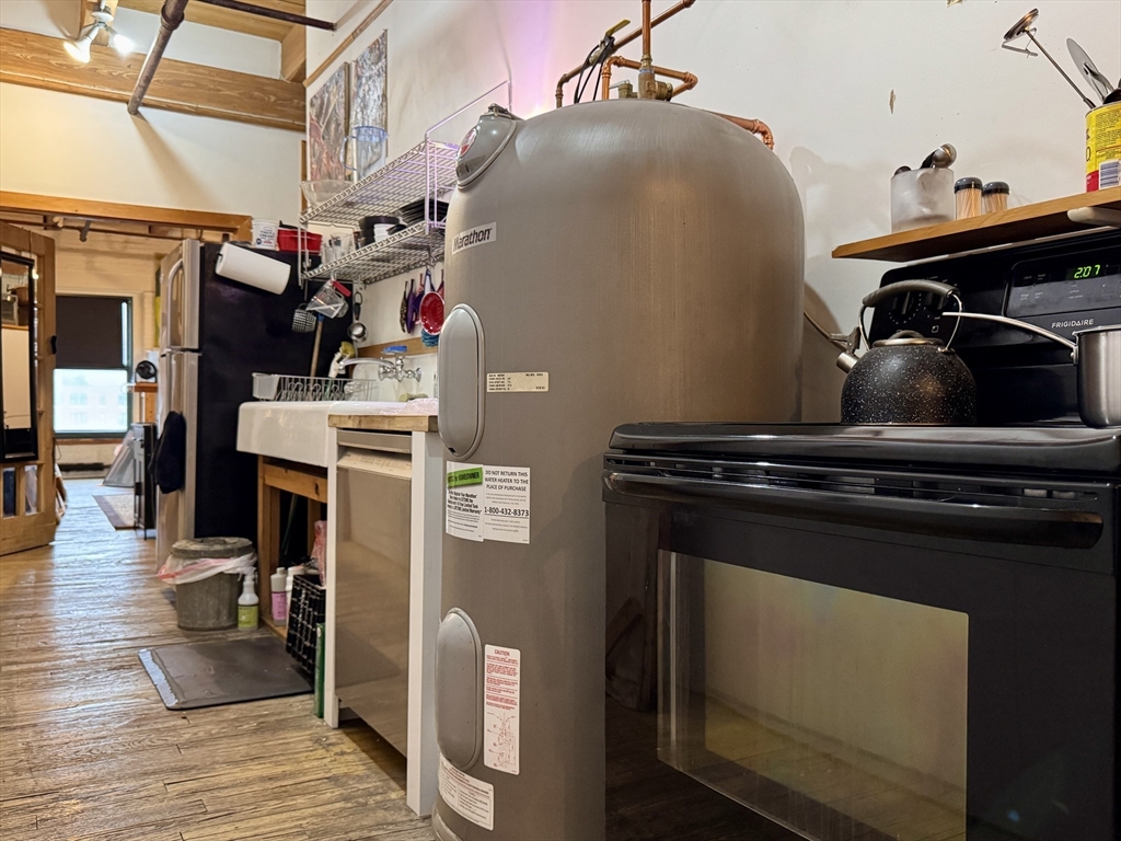 249 A Street, Unit 61 Boston, MA 02210 - Photo 7 of 21 a close view of a refrigerator a stove and wooden floor