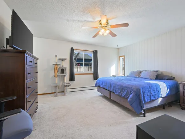 a spacious bedroom with a bed chandelier and a window