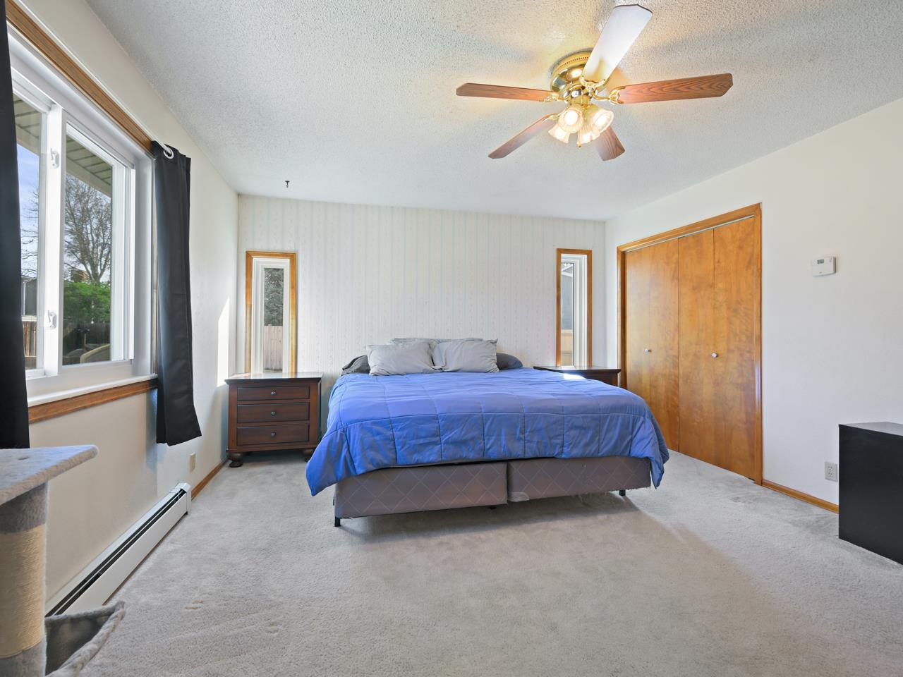 750 Pinyon Court Fruita, CO 81521 - Photo 18 of 40 a spacious bedroom with a bed chandelier and a window